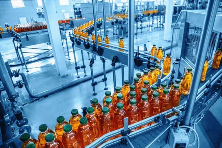 Automated bottling production line with conveyor system handling filled bottles in a modern manufacturing facility
