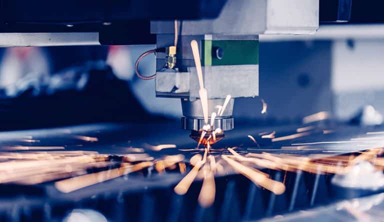 Automated laser cutting process in industrial manufacturing with precision machining and sparks during material processing
