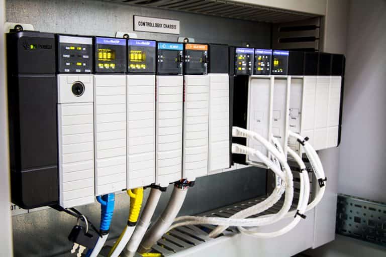 Industrial PLC control panel with automation system wiring and control modules inside a manufacturing environment